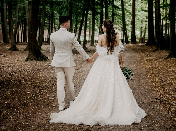 newly wedded couple walking through woods